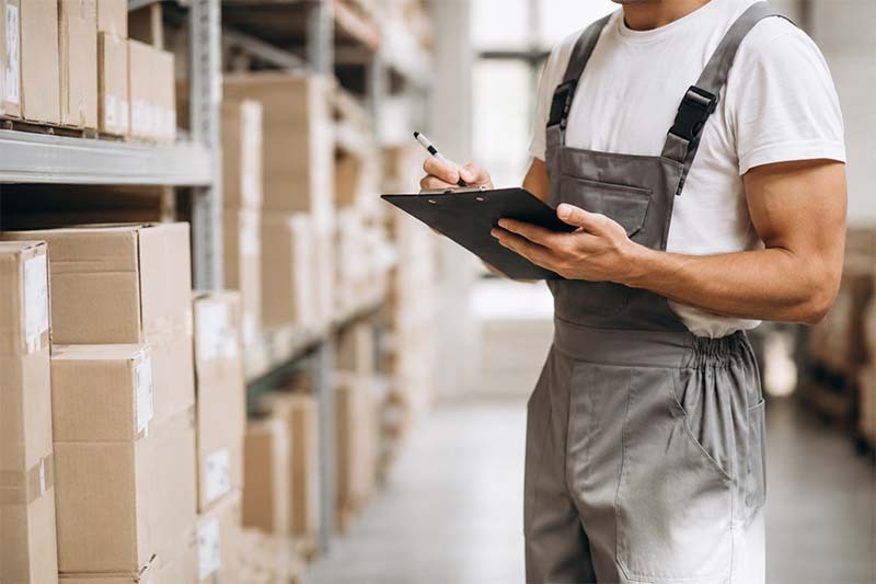 Warehouse worker inspecting inventory in storage Warehouse worker inspecting inventory in storage